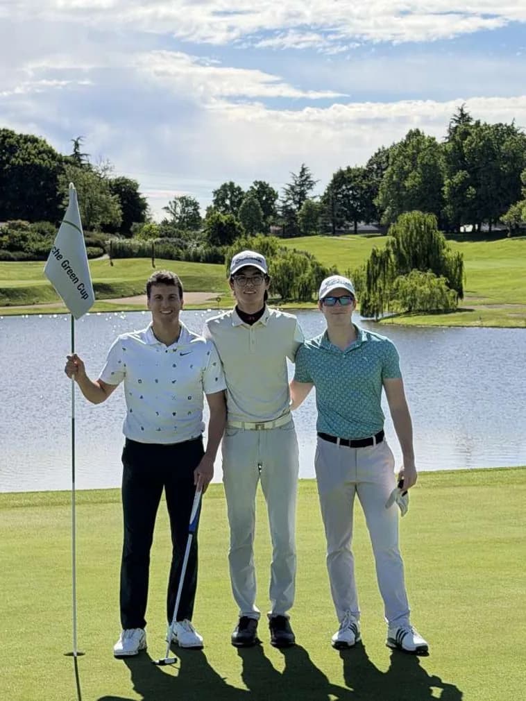 I tre di Bravo Golf abbracciati vicino alla bandiera, con il lago alle spalle
